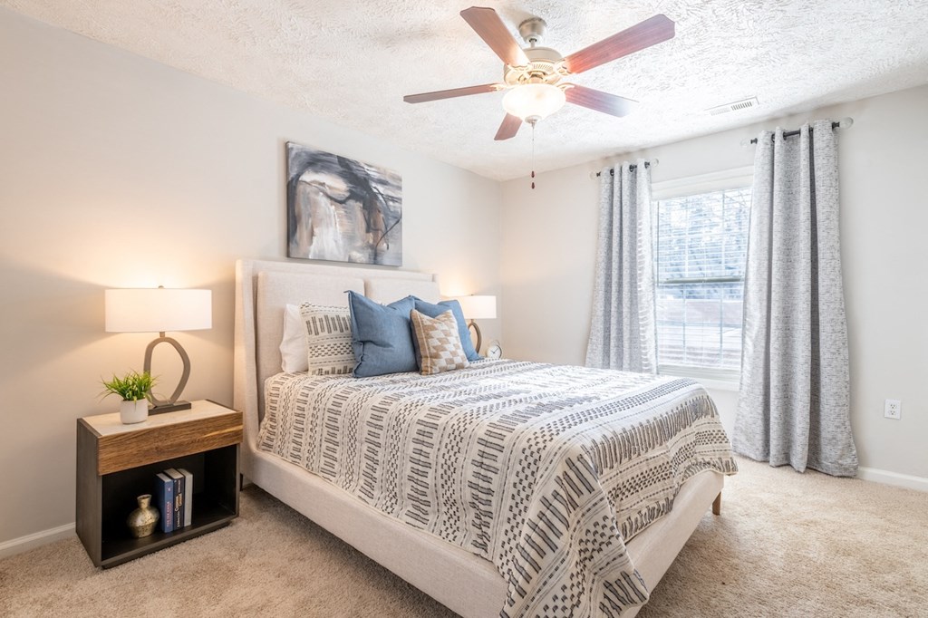 a bedroom with a bed and a ceiling fan
