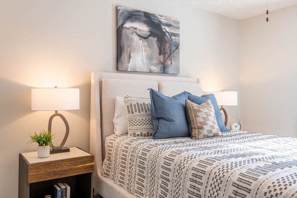 a bedroom with a bed and a painting on the wall