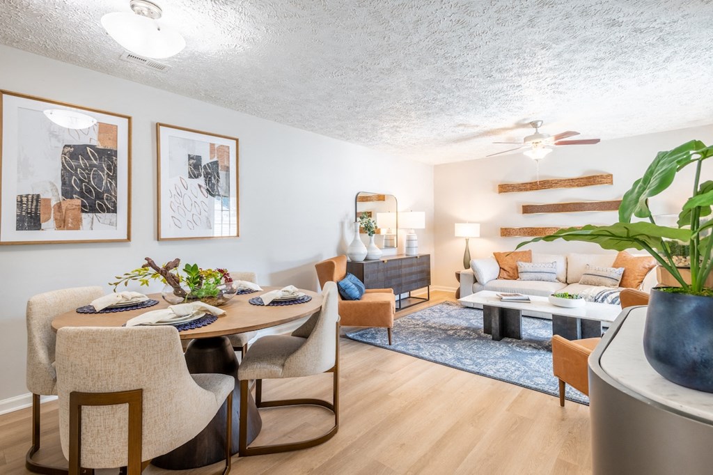 a living room and dining room with a table and chairs