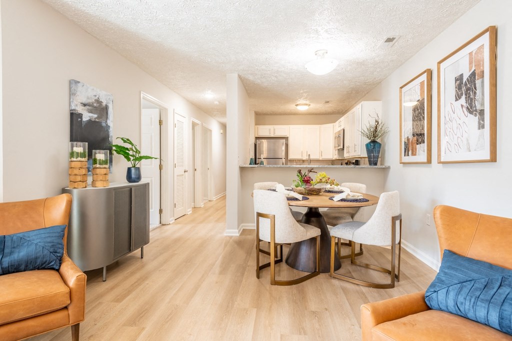 the living room and dining room of an apartment with a table and chairs