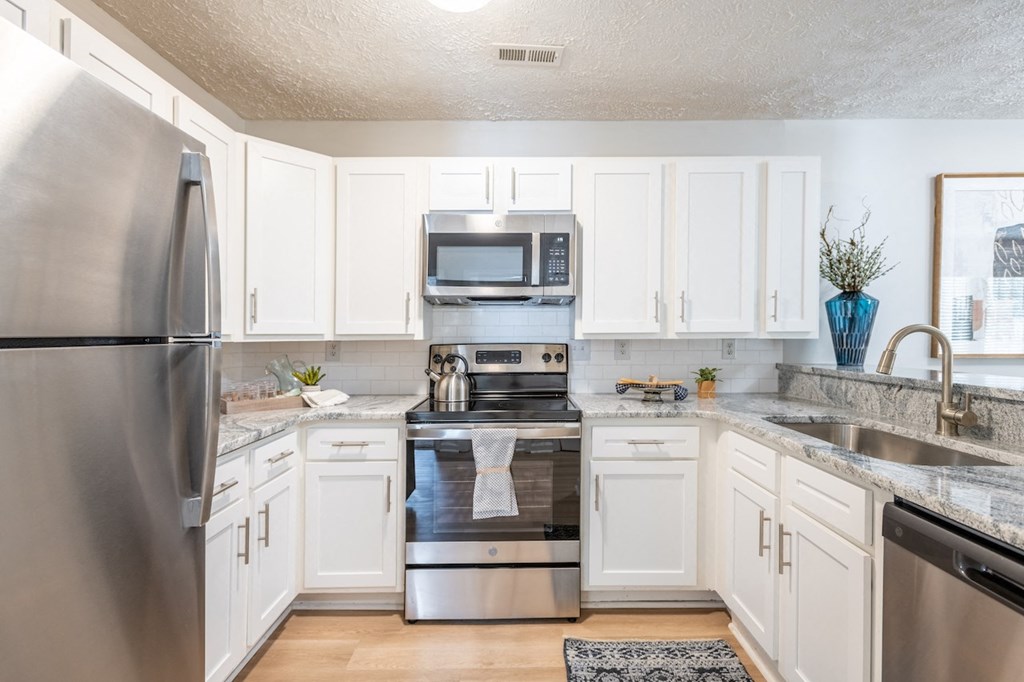 a kitchen with stainless steel appliances and white cabinets