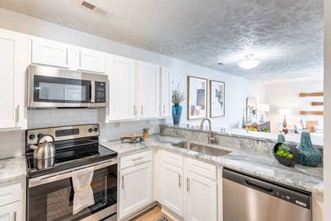 an open kitchen with stainless steel appliances and granite counter tops