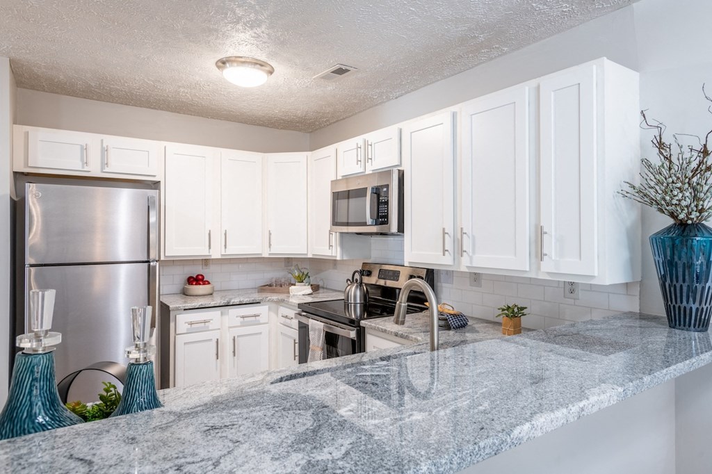 a kitchen with white cabinets and stainless steel appliances