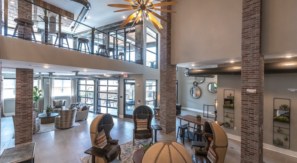 a living room with a large ceiling fan and a glass balcony
