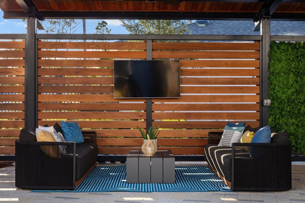a screened in patio with furniture and a television