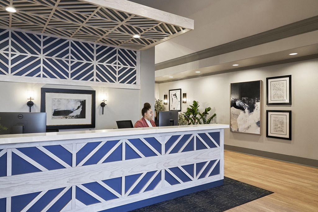 a woman sitting at a reception desk in a hotel lobby