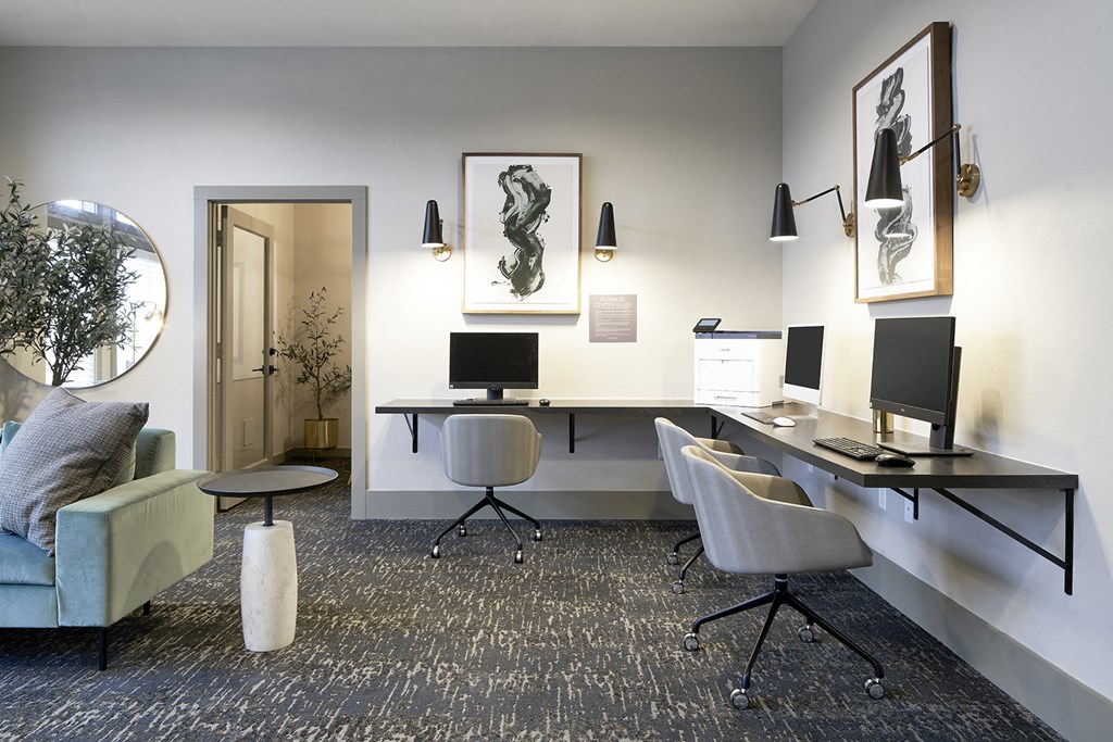 a office with a desk with three monitors and a couch