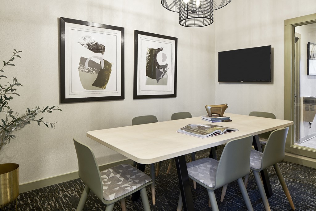 a conference room with a table and chairs and pictures on the wall