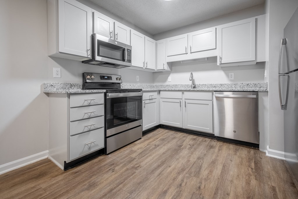 a kitchen with white cabinets and stainless steel appliances