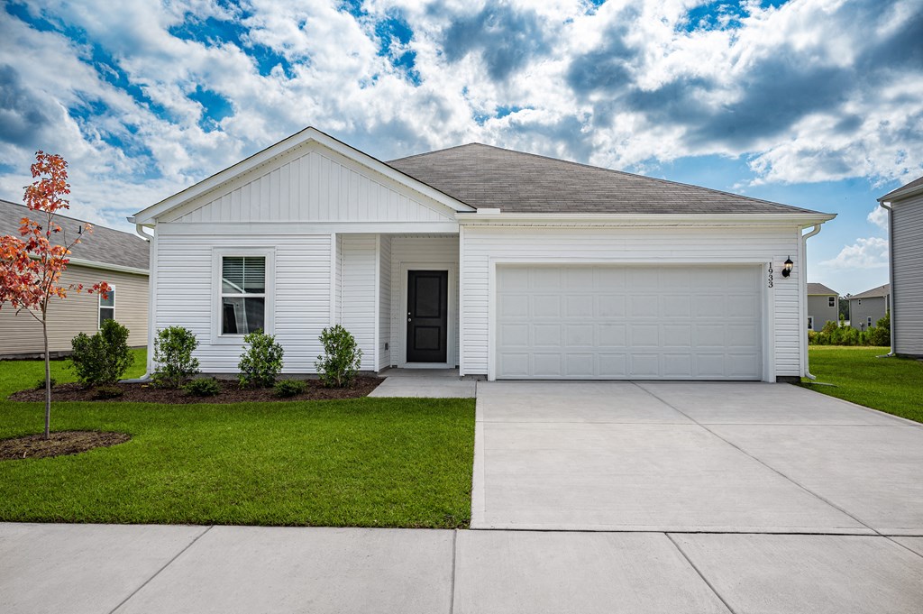 a white house with a driveway and a garage door