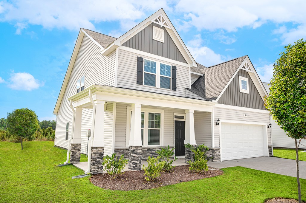 a white and gray house with a lawn and a driveway