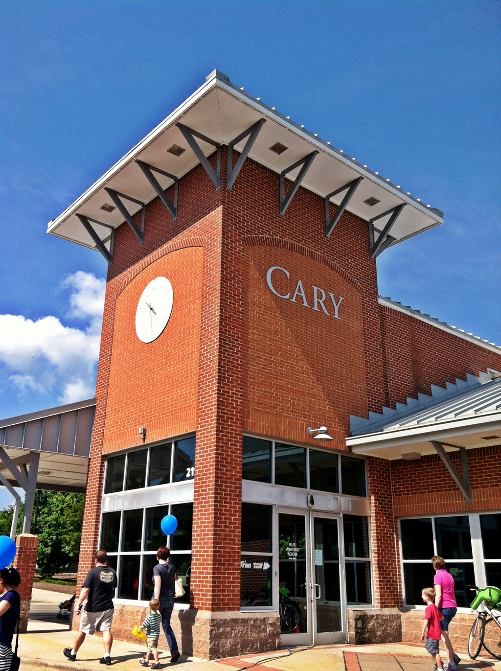 A brick building with a clock on the front and the word Cary on the side.