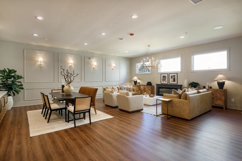 A spacious living room with a dining table and chairs, a couch, a coffee table, and a fireplace.