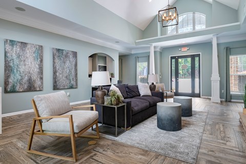 A living room with a wooden chair and a grey couch.