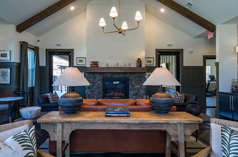 A living room with a fireplace and a table with two lamps on it.