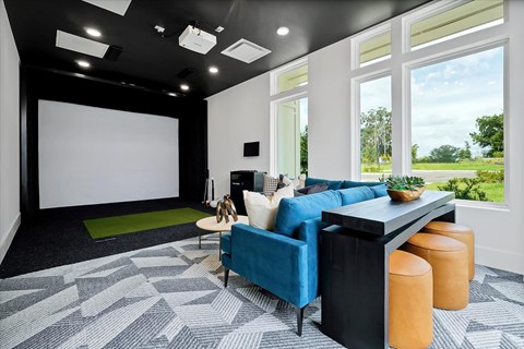 A modern living room with a blue sofa and a green rug.
