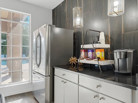 A kitchen with a black countertop and a refrigerator.