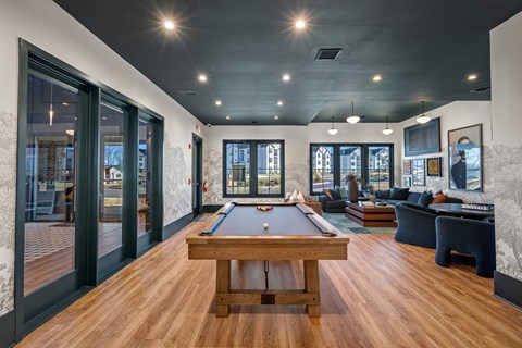 A room with a pool table and a couch.