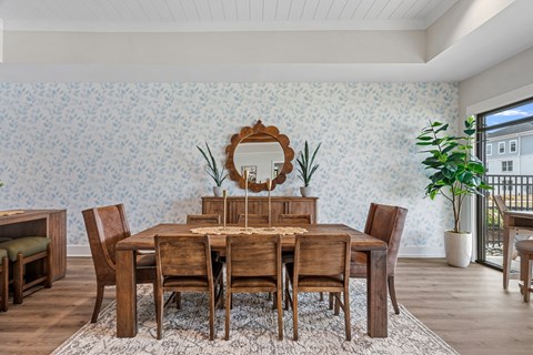 A dining room with a wooden table and chairs.