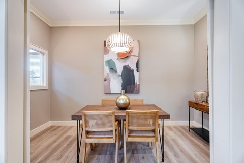 A dining room with a wooden table and chairs.