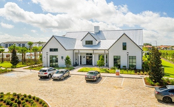 a white house with cars parked in a parking lot