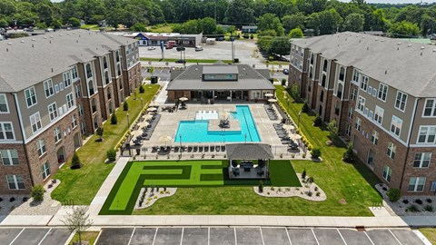 an aerial view of a pool in front of an apartment building