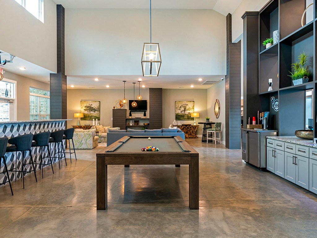 a game room with a pool table and a bar