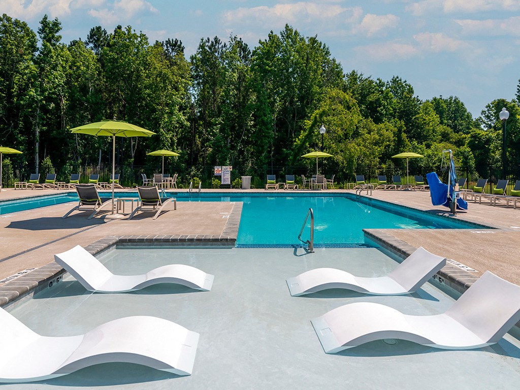a swimming pool with chairs and umbrellas at the resort