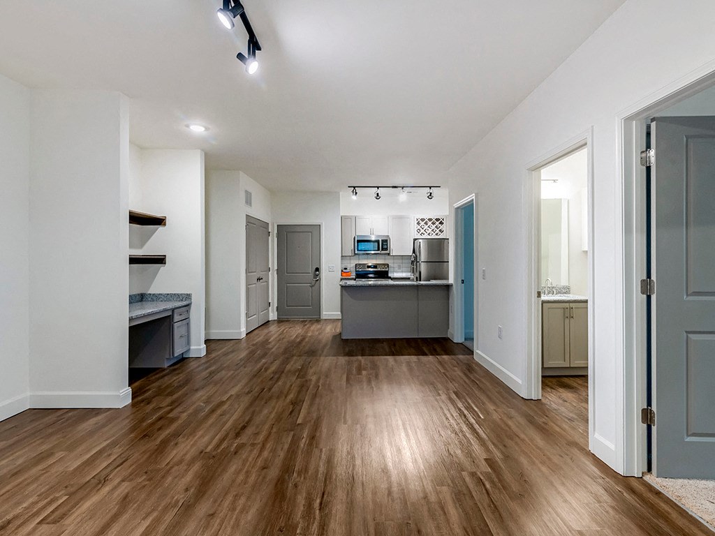 a renovated living room and kitchen with a hard wood floor