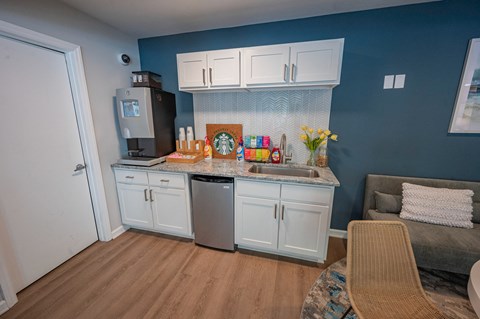 a kitchen with white cabinets and a sink and a counter top