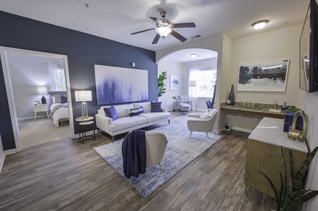 a living room with blue walls and a ceiling fan