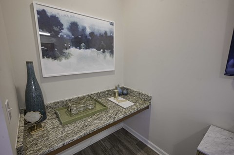 a vanity with a vase and a picture on the wall