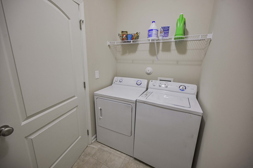 the laundry room has a washer and dryer and a door to the closet