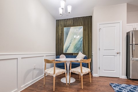 a dining room with a table and chairs and a refrigerator