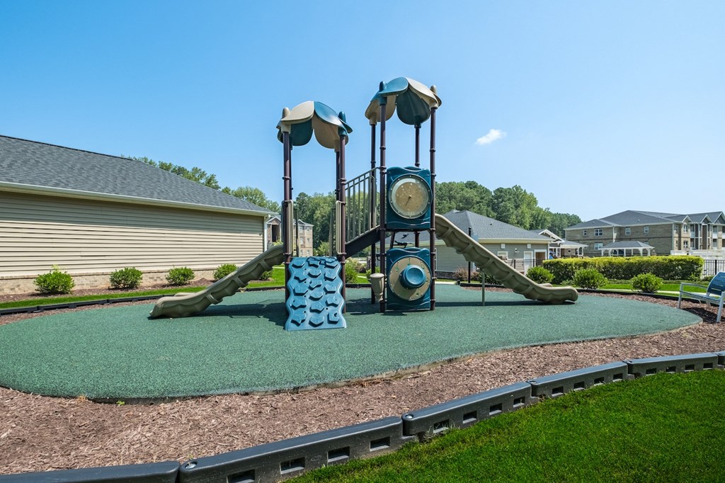 a playground with a swing set and slides in a park