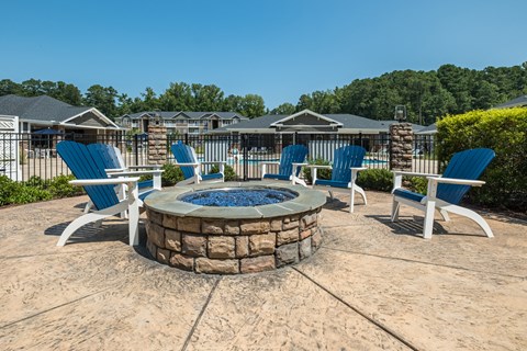 a fire pit with blue chairs and chairs around it