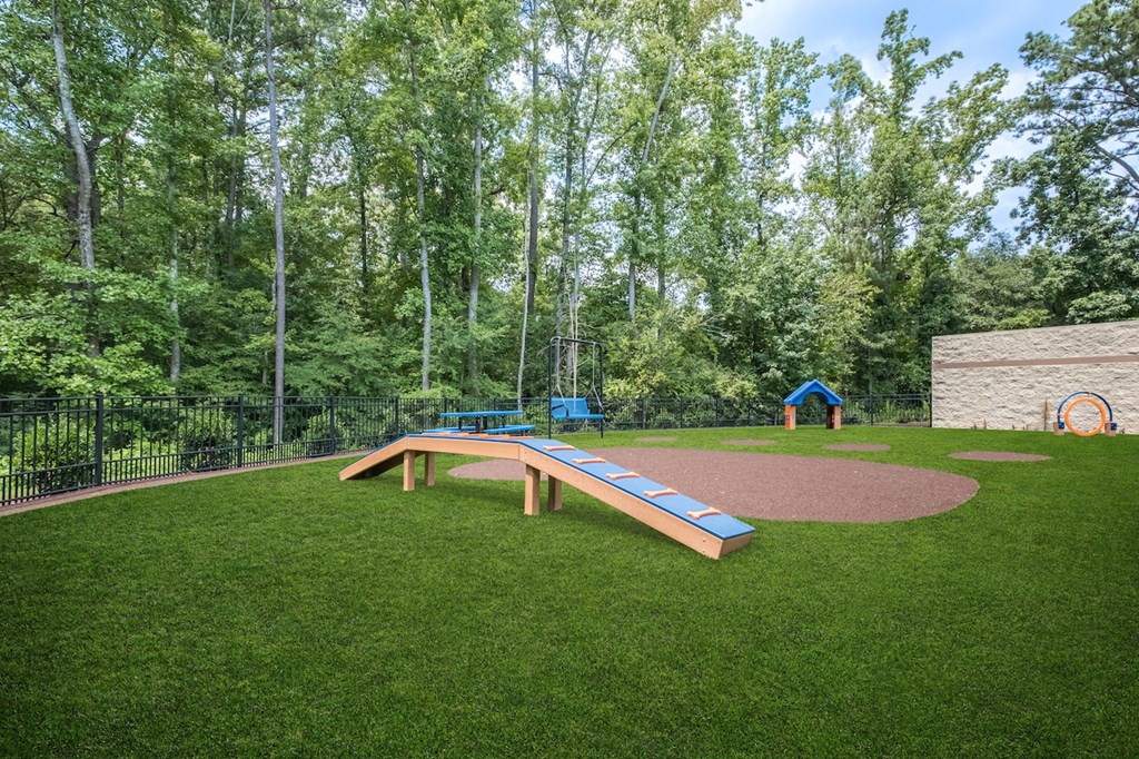 a park with a playground and a picnic table in the grass