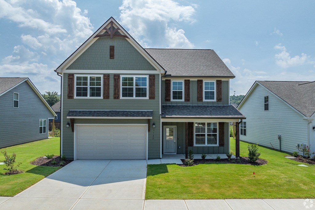 a house with a garage door and a lawn