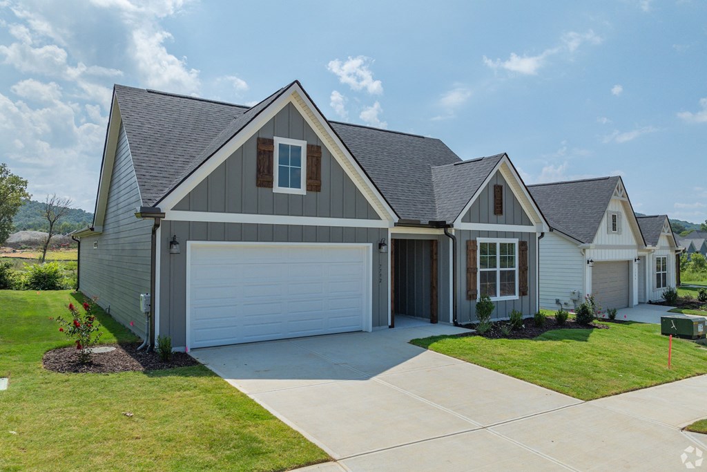 a home with a white garage door and a gray house
