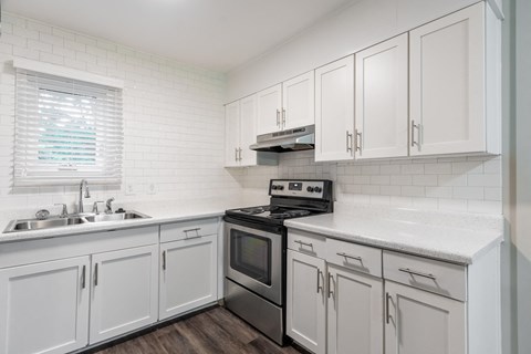 a kitchen with white cabinets and stainless steel appliances