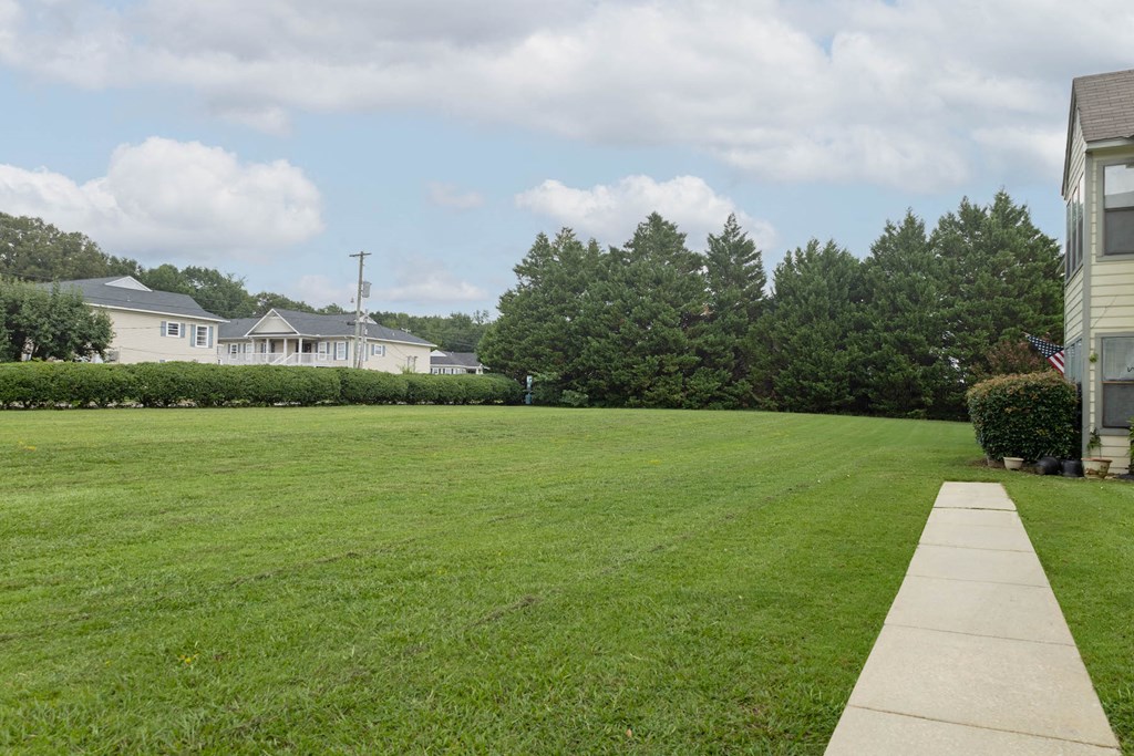 a large lawn in front of a row of houses