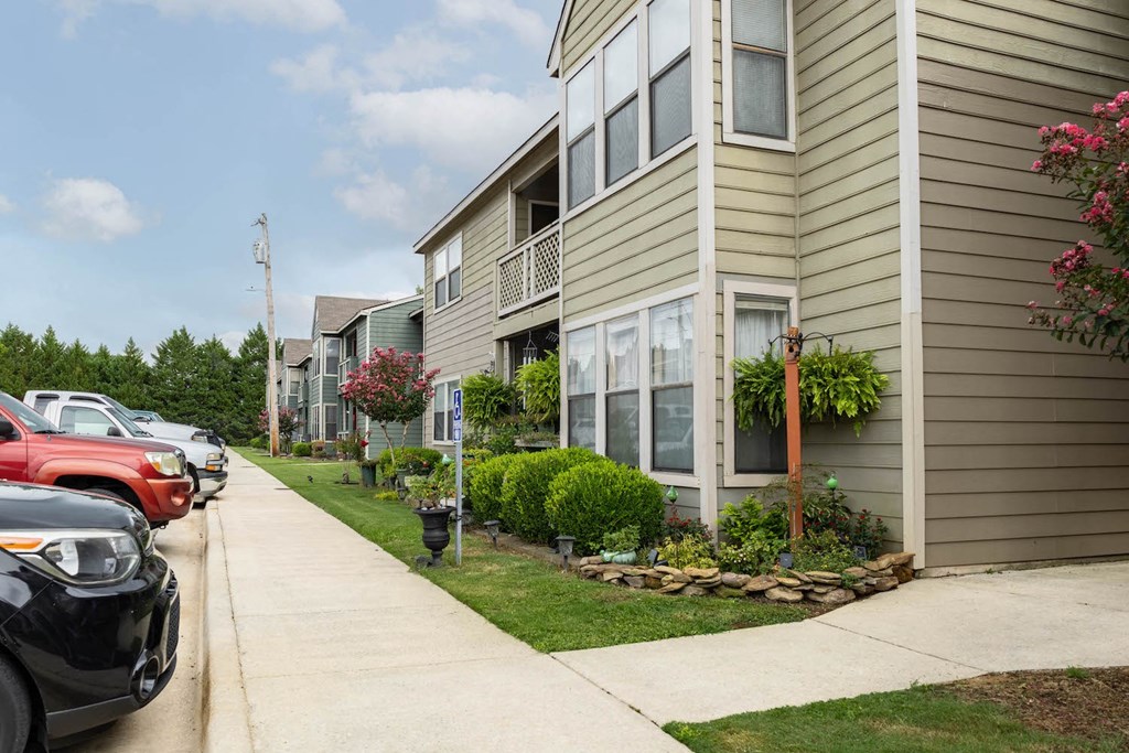 a row of houses with cars parked in front of them