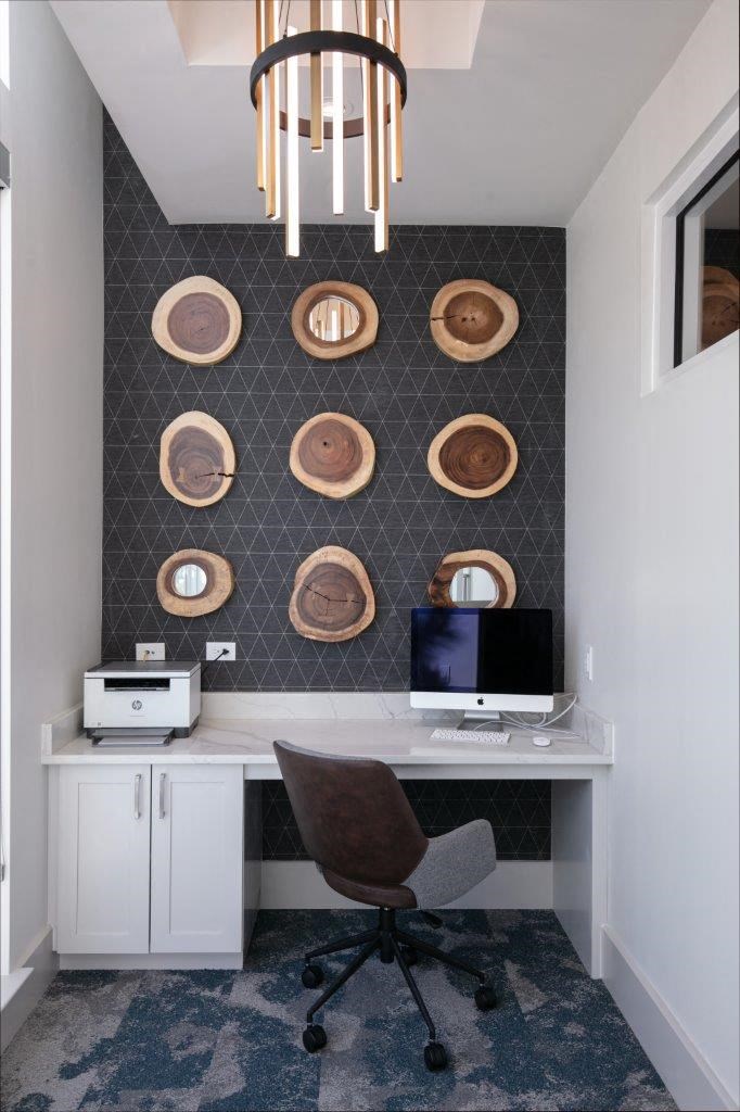 a home office with a computer and a wall with plates on it
