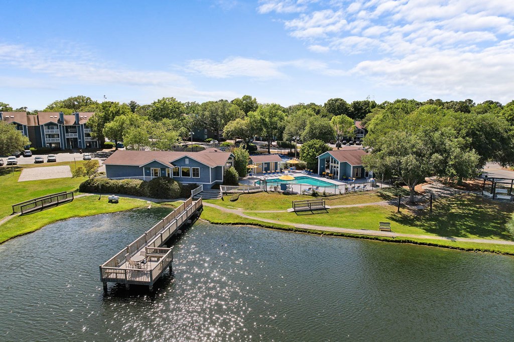 a dock on a body of water with houses in the background