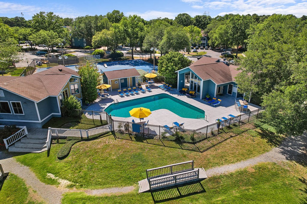 a backyard with a pool and a house with umbrellas