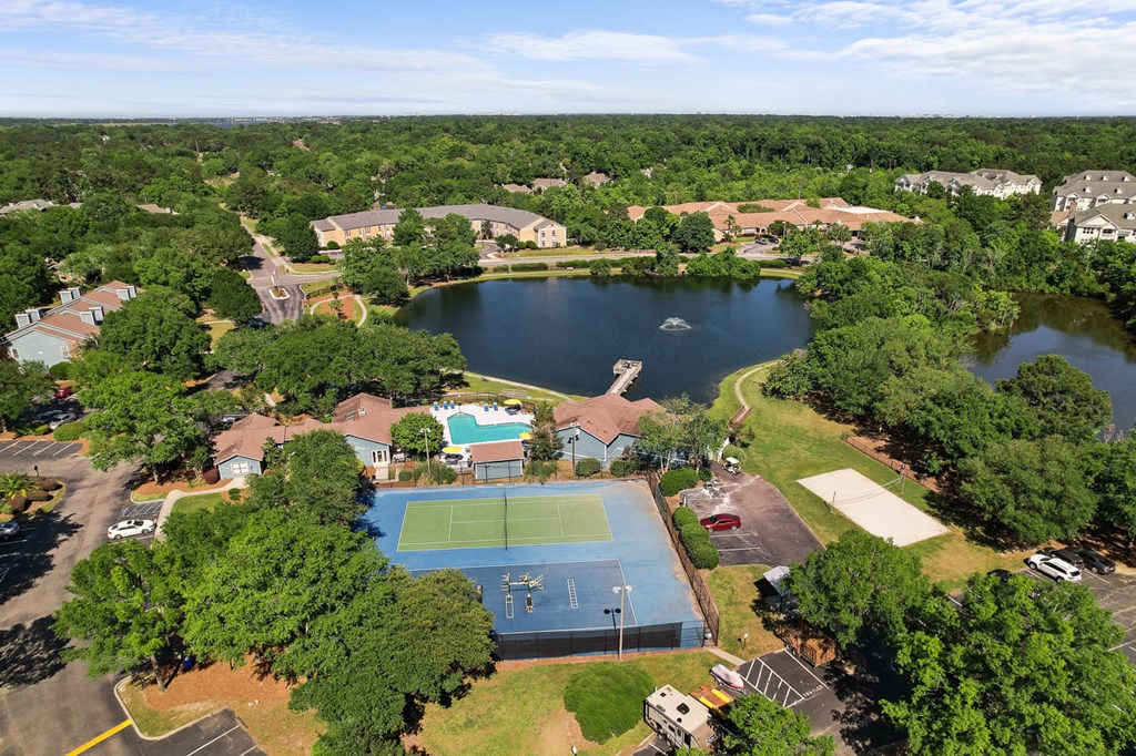 an aerial view of a tennis court and a lake