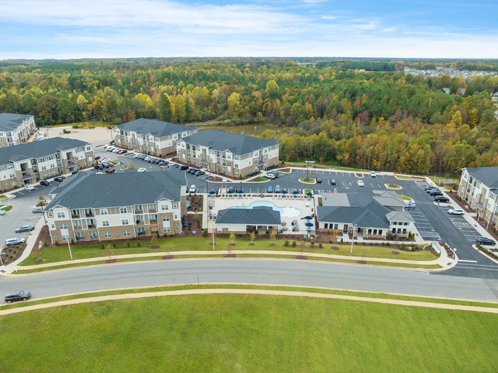 an aerial view of an apartment complex with cars parked in a parking lot