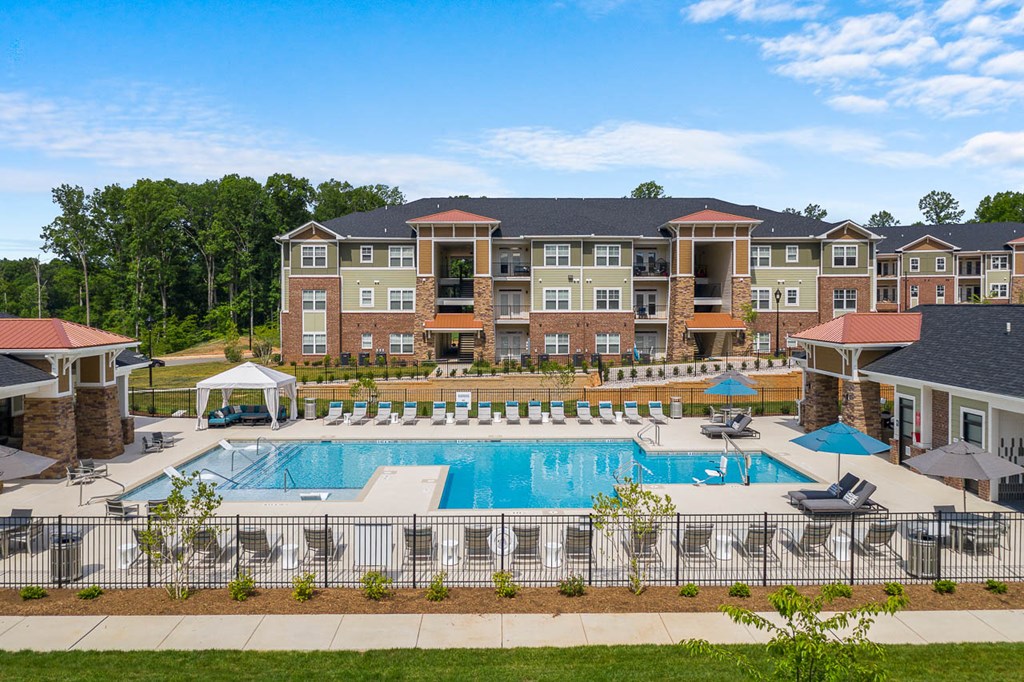 an aerial view of a swimming pool with apartments in the background