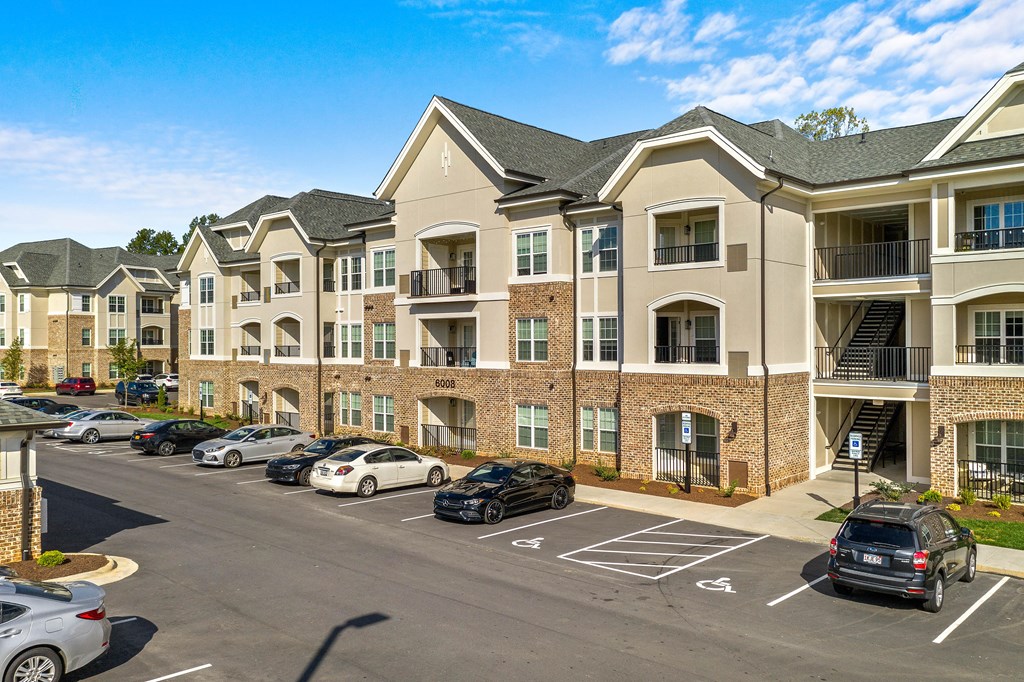 a large apartment building with cars parked in a parking lot