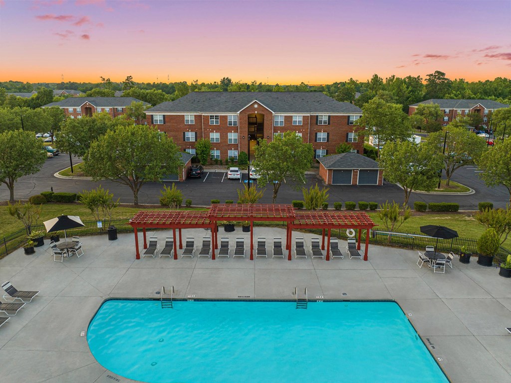 an aerial view of a swimming pool with a hotel in the background